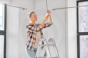 woman changing light bulb at new home