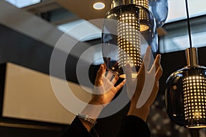 Woman changing light bulbs in the kitchen. Electric LED bulbs change home lighting. Woman\'s hand is changing a light bulb