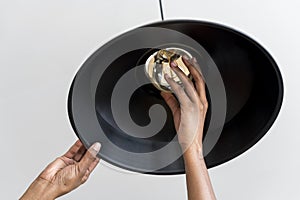 Woman is changing a lightbulb