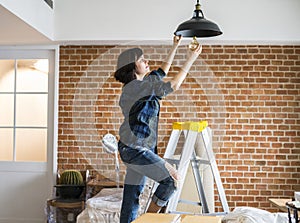 Woman changing lightbulb at home