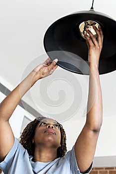 Woman changing lightbulb in the house