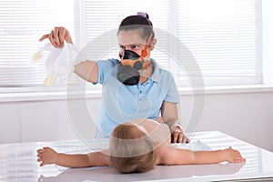 Woman Changing Smelly Nappy Of Her Baby