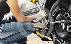 Woman changing tire car photo