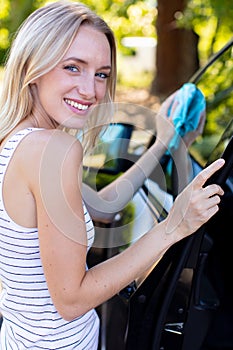 woman changing windscreen wipers on car