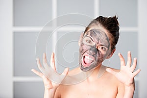 Woman with charcoal facial mask. Beautiful young woman with facial black mud clay mask. Skin care and treatment, spa