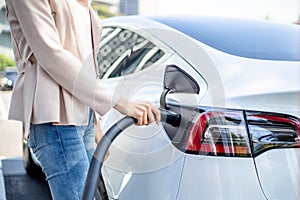 Woman charging electric car