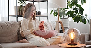Woman chatting using mobile phone at home