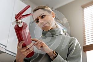 Woman check the fire extinguisher expiration date at home photo