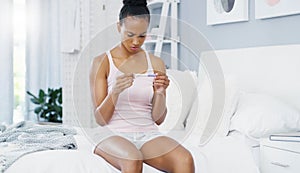 Woman, check pregnancy test and worry on bedroom with anxiety, stress or thinking in home. African girl, pregnant