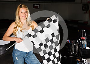 woman with checkered race flag standing near sport car