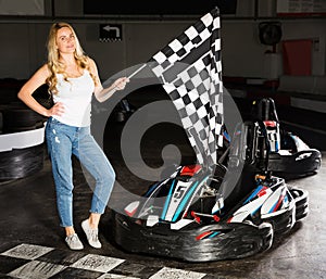 woman with checkered race flag standing near sport car