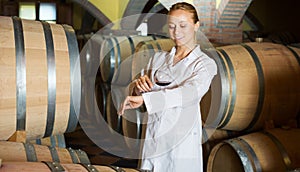 Woman checking ageing process of wine