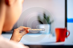 Woman Checking Body Temperature Using Thermometer. Health Research And Examination And Self Quarantine And Isolation