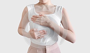 Woman checking breast cancer by herself, on white background. Self check breast cancer on woman