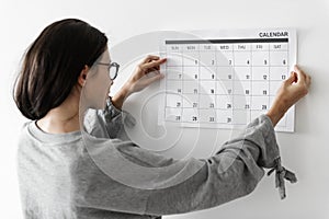 Woman checking the calendar on wall