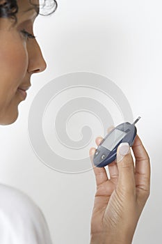 Woman Checking Diabetes using Glucometer photo