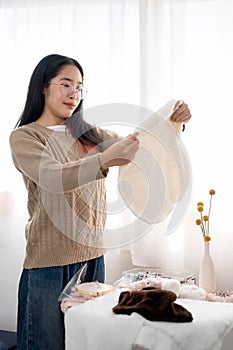 A woman checking fabric for her handcraft items, preparing sewing accessories at the table