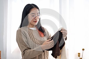 A woman checking fabric for her handcraft items, preparing sewing accessories at the table