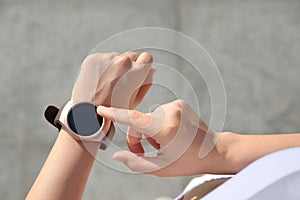 Woman checking fitness tracker after training outdoors, closeup