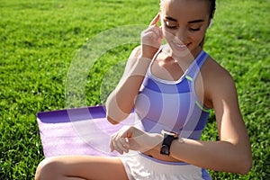 Woman checking fitness tracker after training in park