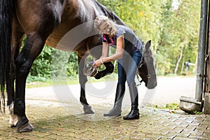 Woman Checking Her Horse`s Hooves