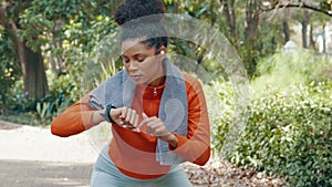 Woman checking her pulse with a smart watch while on a health, fitness and wellness run in nature. Active girl on a jog