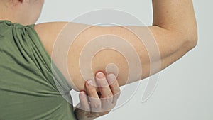 Woman checking her upper arm and excess fat