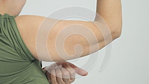 Woman checking her upper arm and excess fat