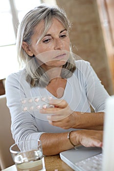 Woman checking instructions on internet for medicaments