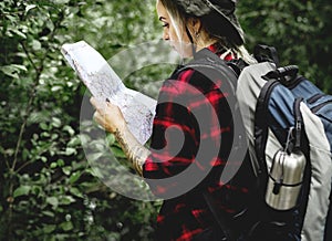 Woman checking map in the forest