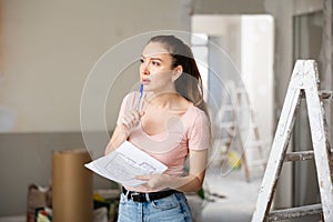 Woman checking plan of house being renovated