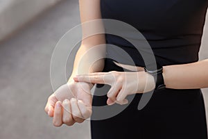 Woman checking pulse after training outdoors, closeup