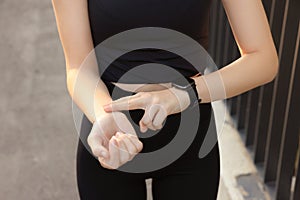 Woman checking pulse after training outdoors, closeup