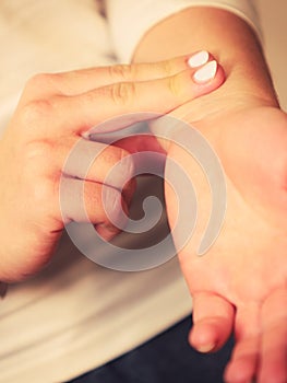 Woman checking pulse on wrist closeup