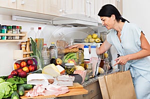 Woman checking purchases in kitchen