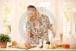 Woman checking recipe in kitchen