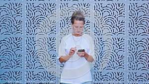 A woman checking the smartphone in the street