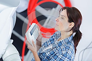 Woman checking thermostat house