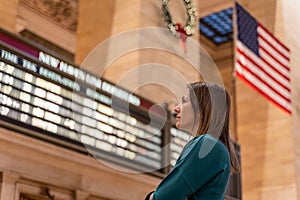 Woman checking the train timetable in the grand central terminal in new york