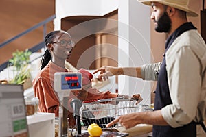 Woman at checkout counter with groceries