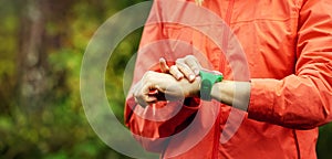 Woman checks results on smartwatch after outdoor workout. copy space