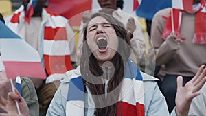 Woman cheering with french flag during football match