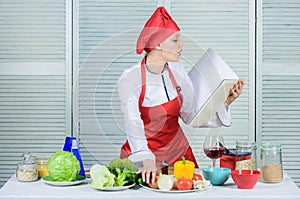 Woman chef cooking food. Culinary concept. Amateur cook read book recipes. Girl learn recipe. Book by famous chef