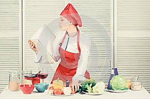 Woman chef cooking food. Culinary concept. Amateur cook read book recipes. Girl learn recipe. Book by famous chef