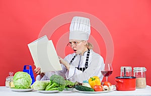 Woman chef cooking healthy food. Girl read book best culinary recipes. Culinary education concept. Female in hat and