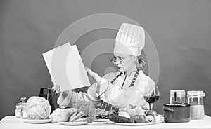Woman chef cooking healthy food. Girl read book top best culinary recipes. Culinary school concept. Female in hat and
