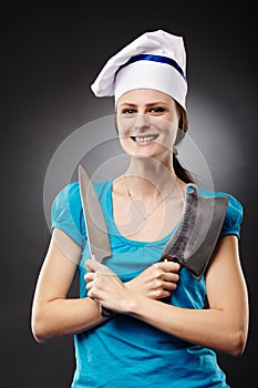 Woman chef holding a knife and a chopper