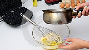 Woman chef mixing melted butter,eggs,cooking dough for baking waffles,pancakes.Morning breakfast food,recipe instruction