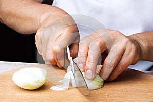 Woman chef prepares onions in the kitchen.