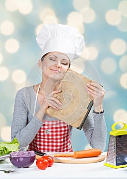 Woman in chef's hat with the old grandmother's cookbook